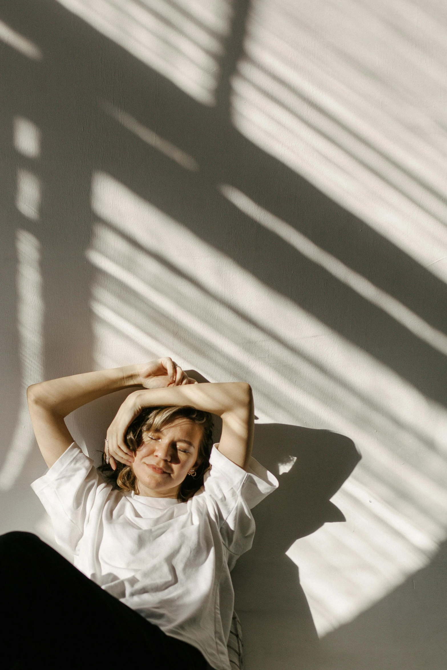 a woman sitting on the ground in front of a shadow