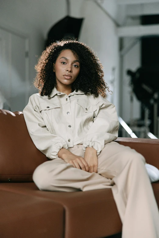 a woman in white sitting on a brown couch