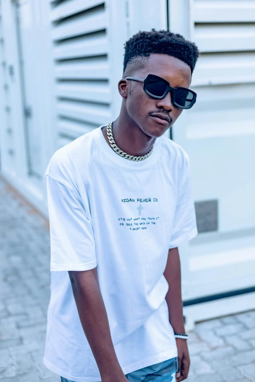 a young black man wearing sunglasses and a white shirt