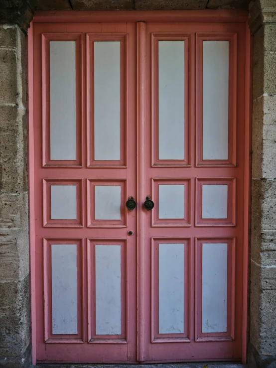 a double red door on an old brick building