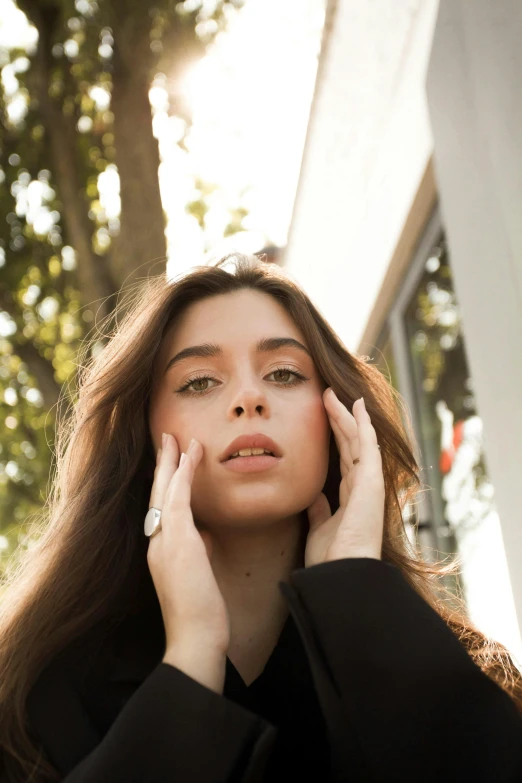 a woman wearing a white ring is holding her head with one hand