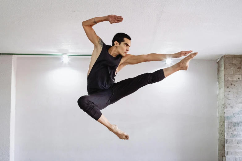 a young man jumping in the air while holding on to his leg