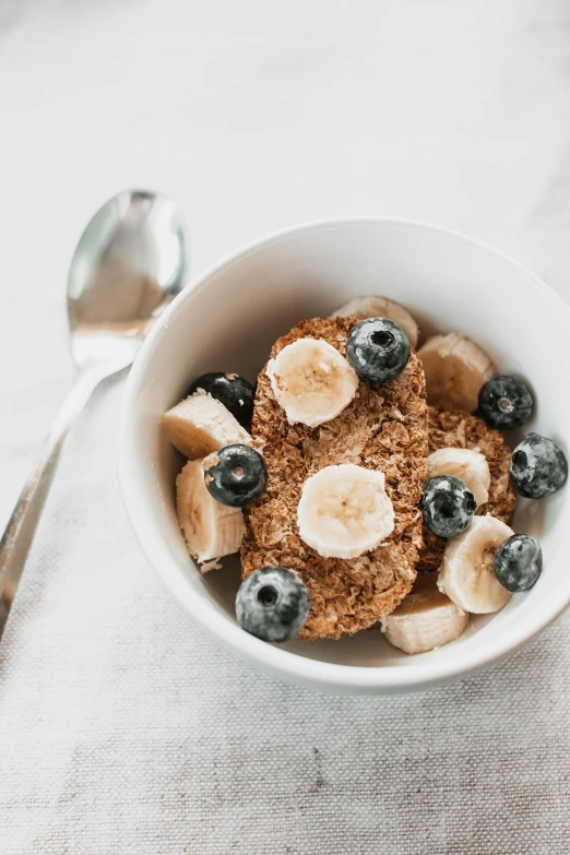 a bowl of cereal topped with bananas and blueberries
