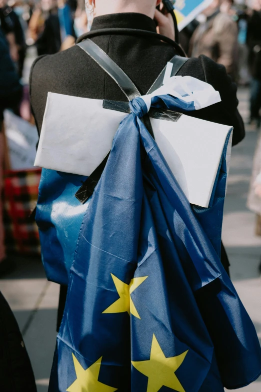 a person with an award ribbon holding bags in one