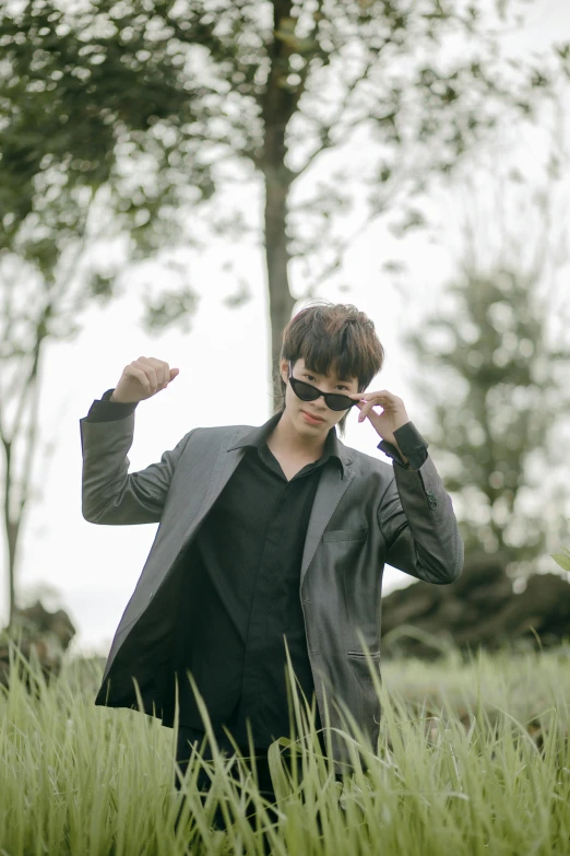 a man in sunglasses walking through tall grass