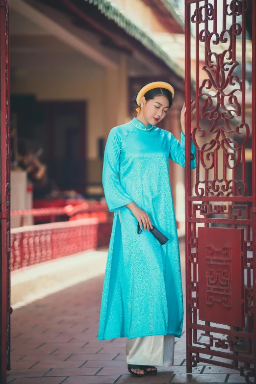 a woman in blue stands at a gate