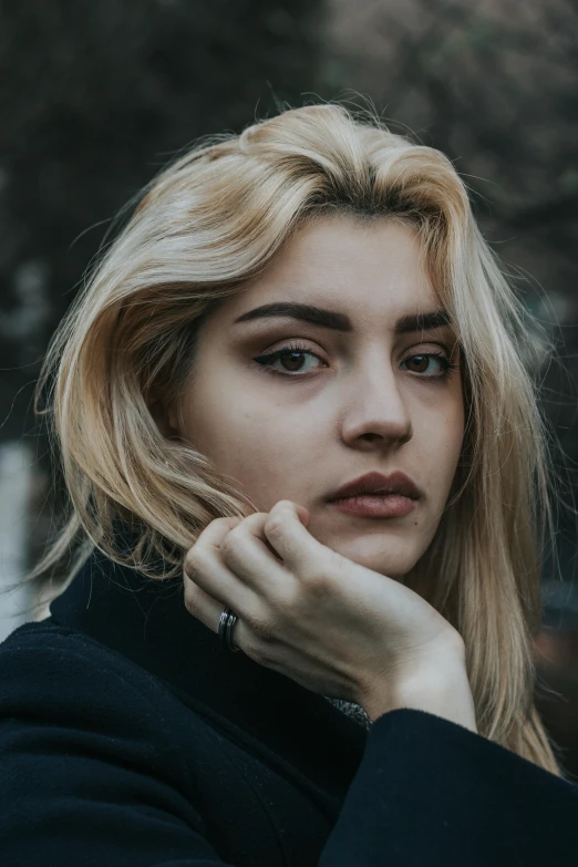 a girl is looking into the camera and wearing blue jacket