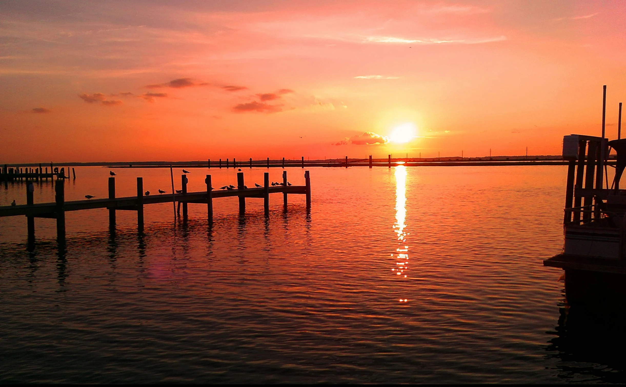 the sun is setting over the water in the sea