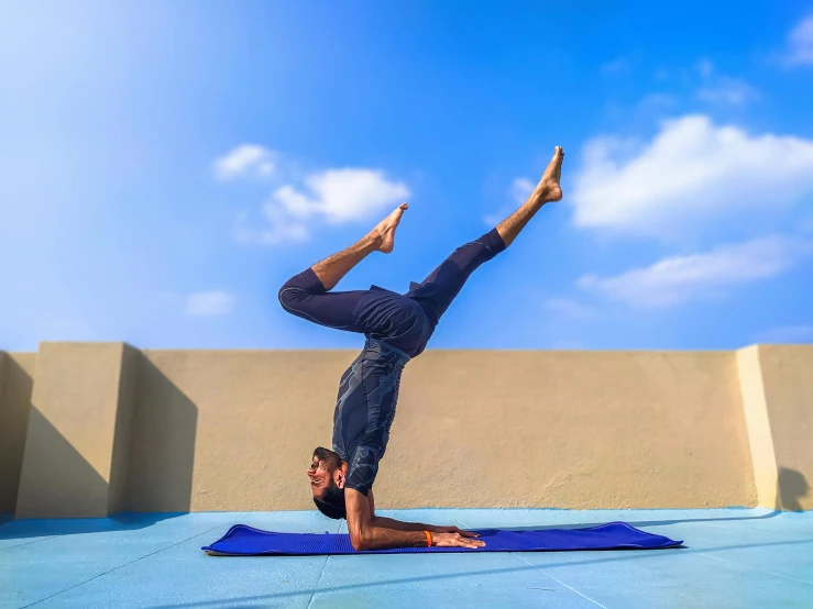 a person doing a hand stand on a mat