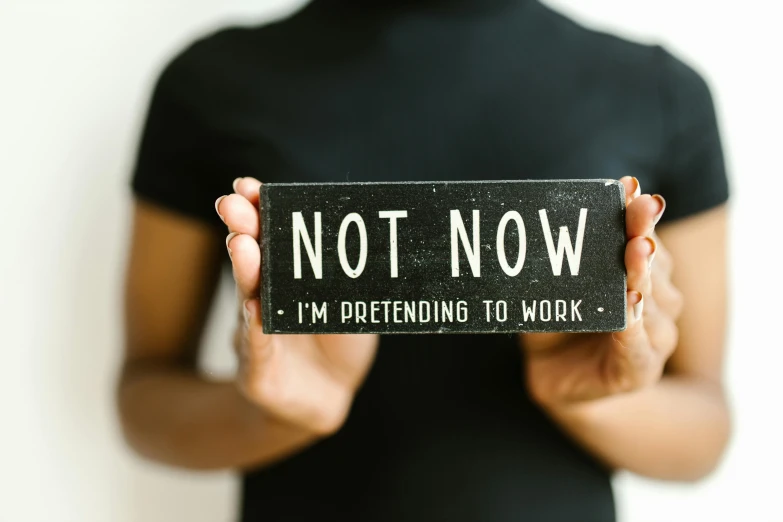 a woman holding up a sign saying not now