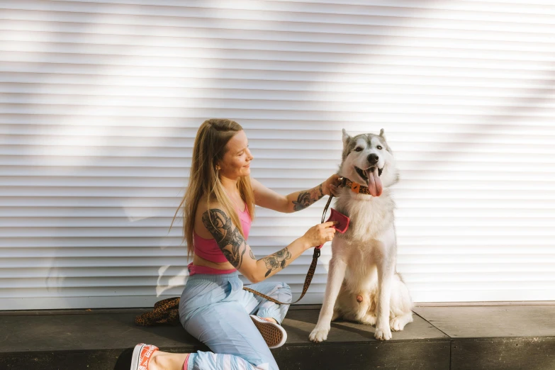 girl on step with large white dog in front of her