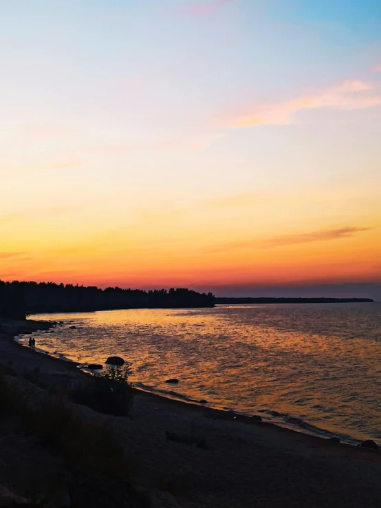 the beautiful sunset lights up the sky over a lake