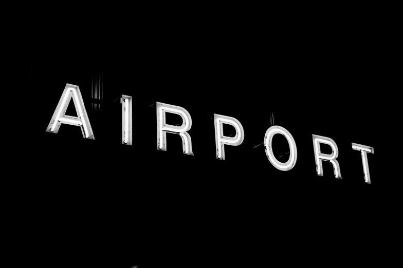 the word airport spelled with white paint on black