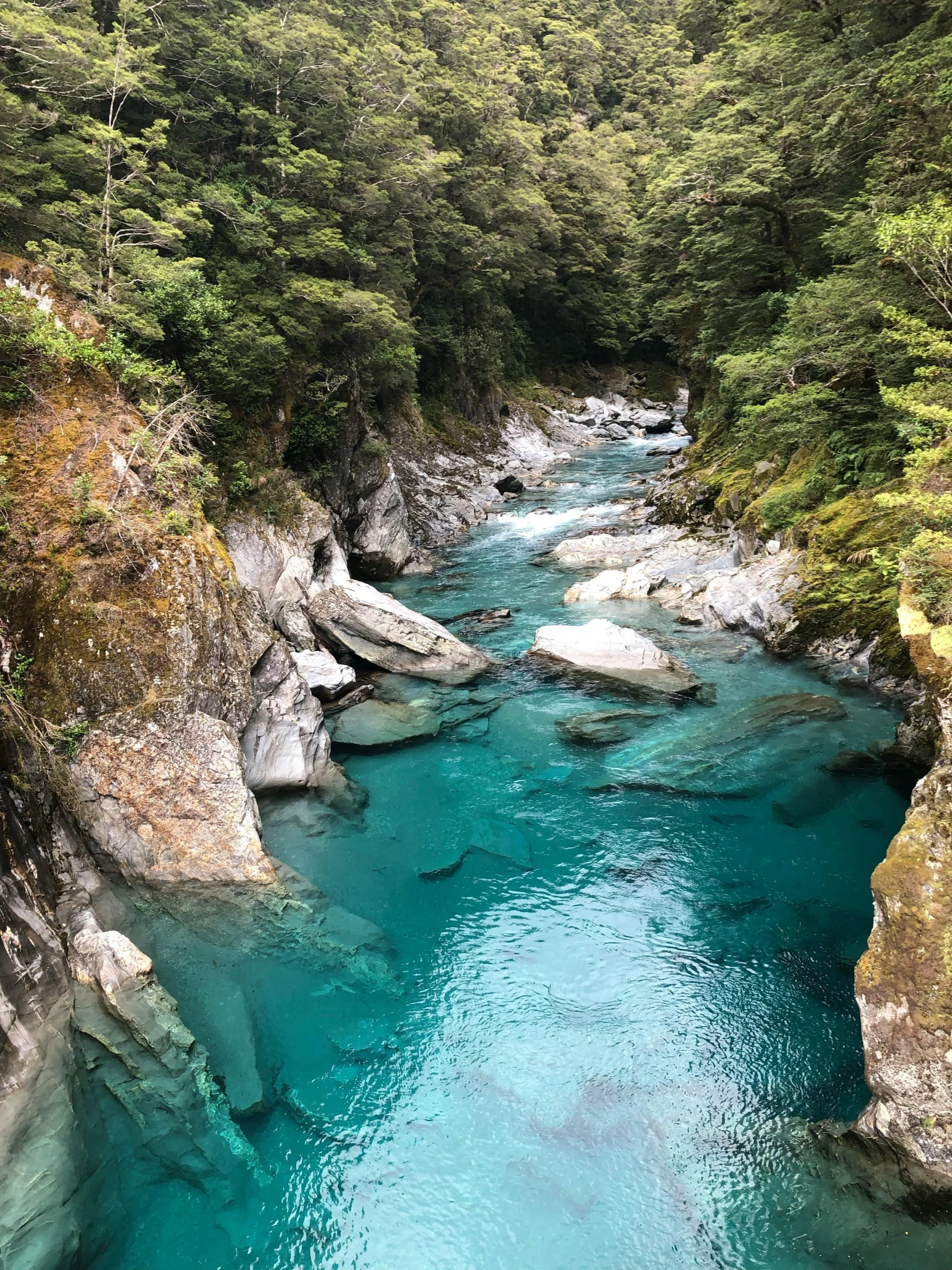 the blue water is flowing down from an overflowed cave