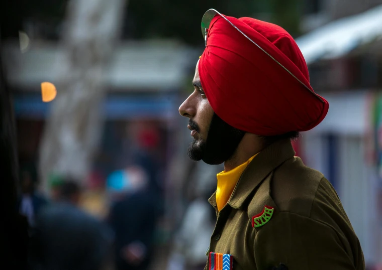 a man in a turban stares away from the camera