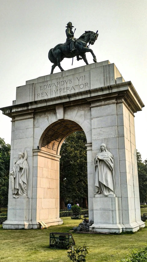 a statue in the grass with a man riding a horse