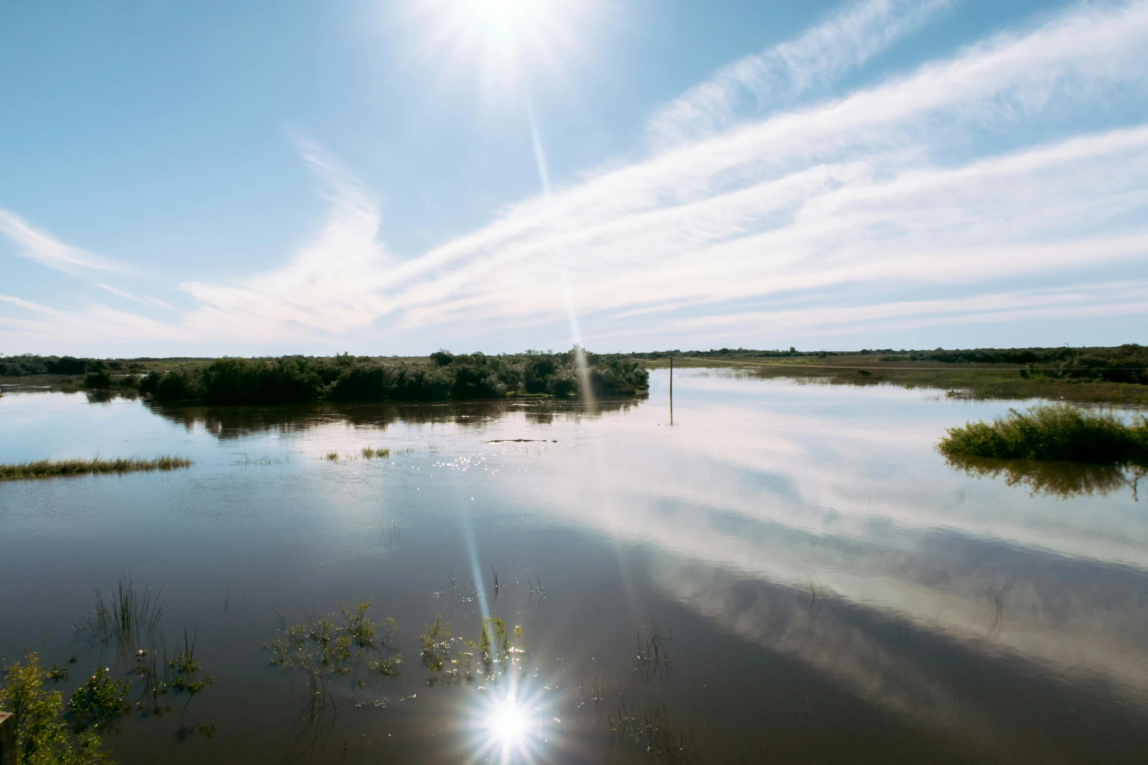 the sun is shining over the water on a sunny day