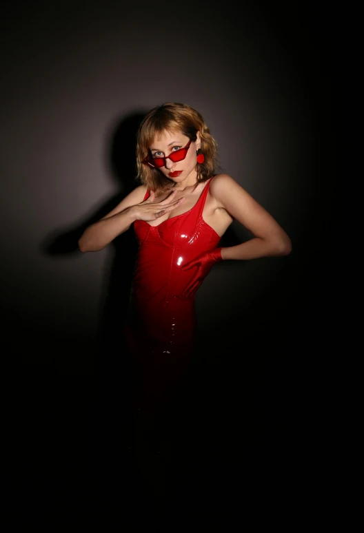 woman with red sunglasses and a shiny red dress