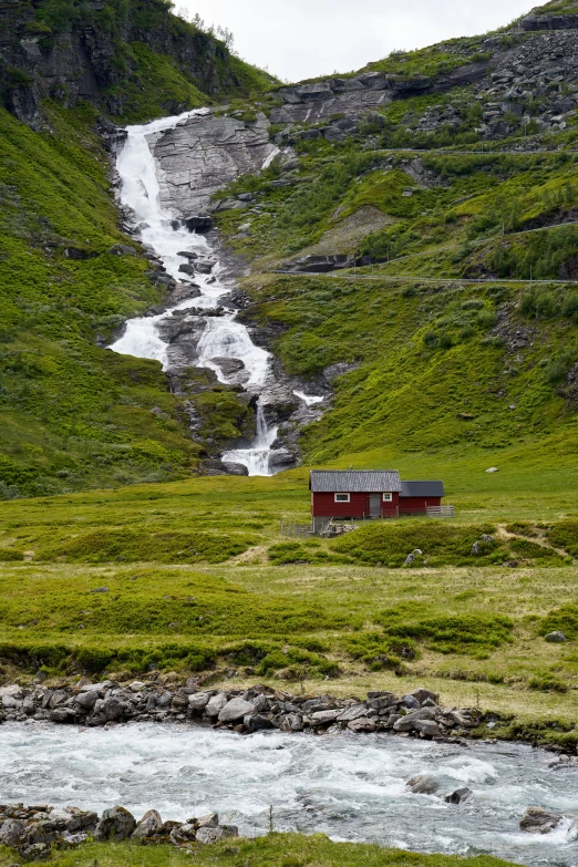 some houses in the mountains by a stream