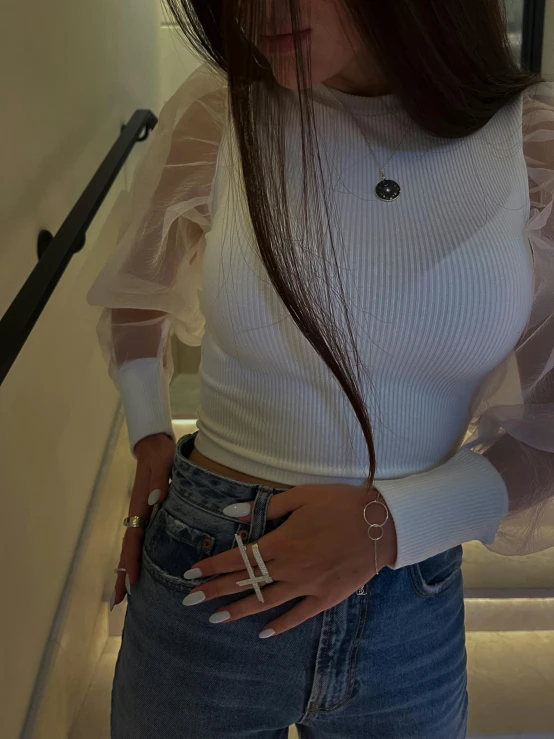 a girl wearing jeans holding a hair straightener