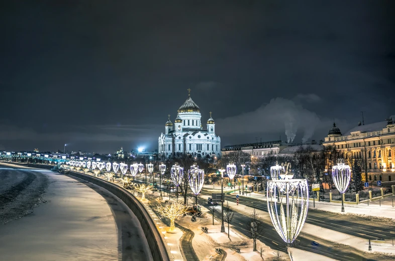 the view of the street lights on the side and some buildings in the background