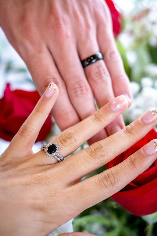 two hands hold together and show off their wedding rings