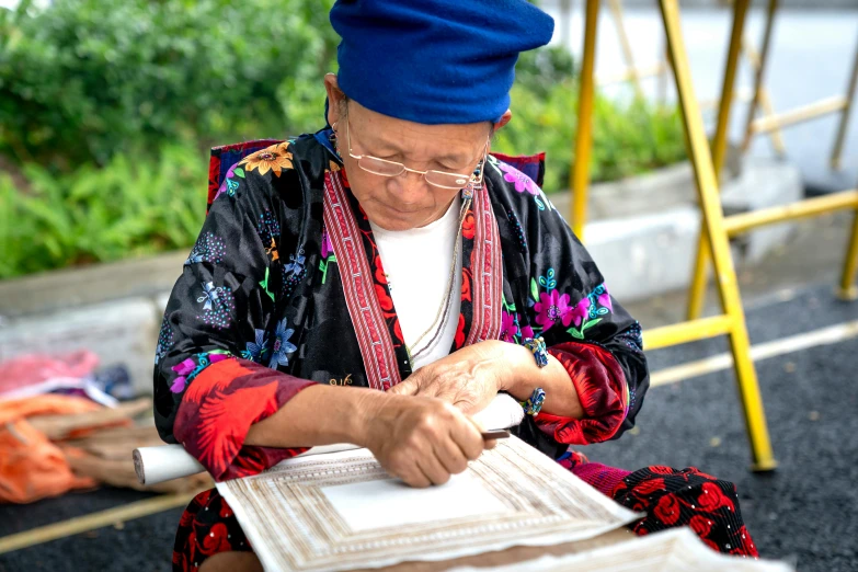 an older woman sitting in front of a large book
