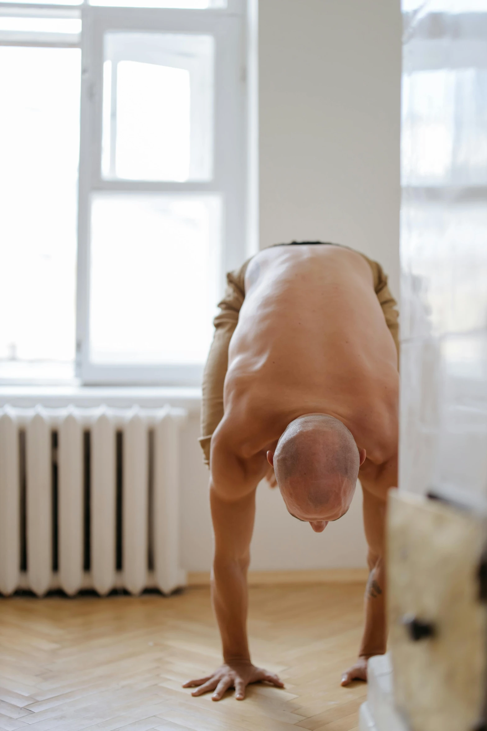 man with no shoes doing yoga on his knees