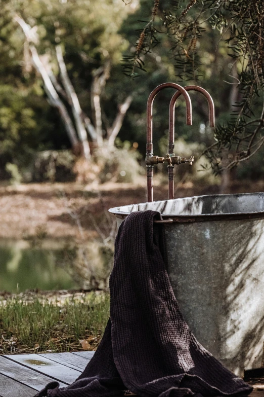 a bathtub with an iron handrail and a towel hanging in it