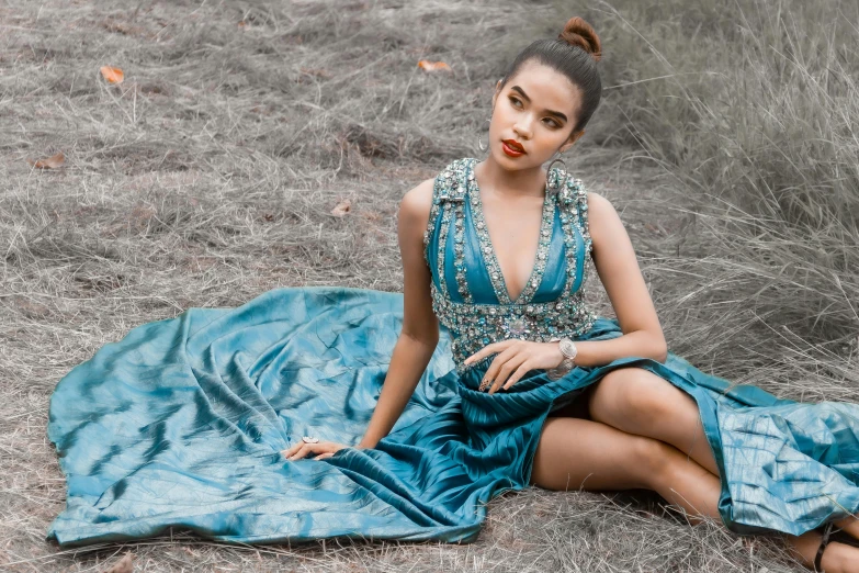 a woman in a dress sitting on the ground