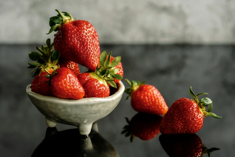 an old pottery bowl has seven strawberries in it