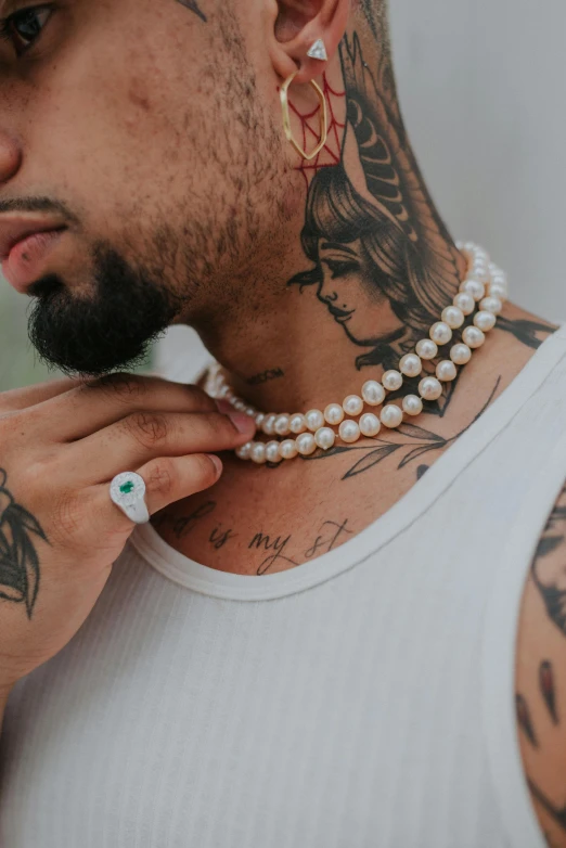 a man with tattoos and a large necklace on