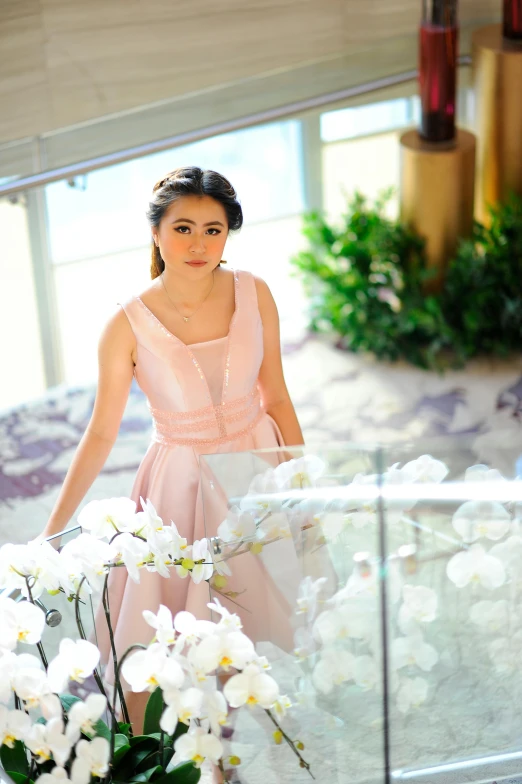 a woman stands in front of a display with white flowers