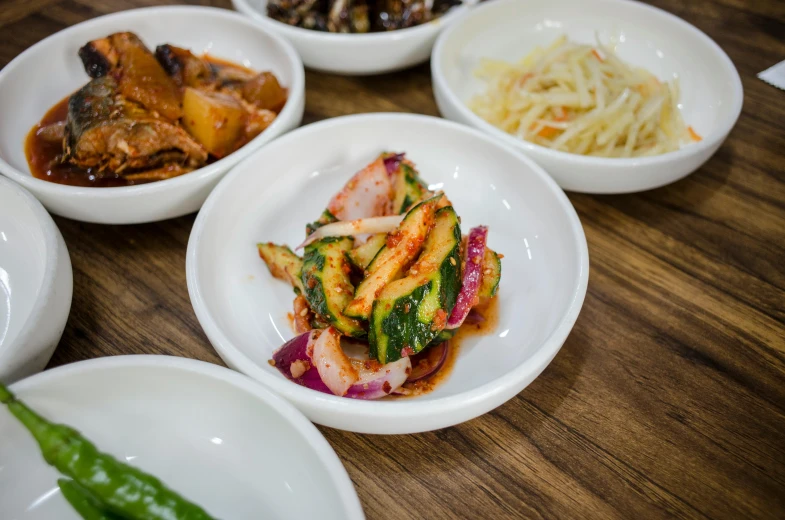 bowls with different foods sitting on top of a wooden table