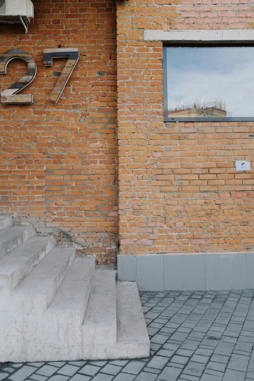 a window, sign and stairs near an old brick building