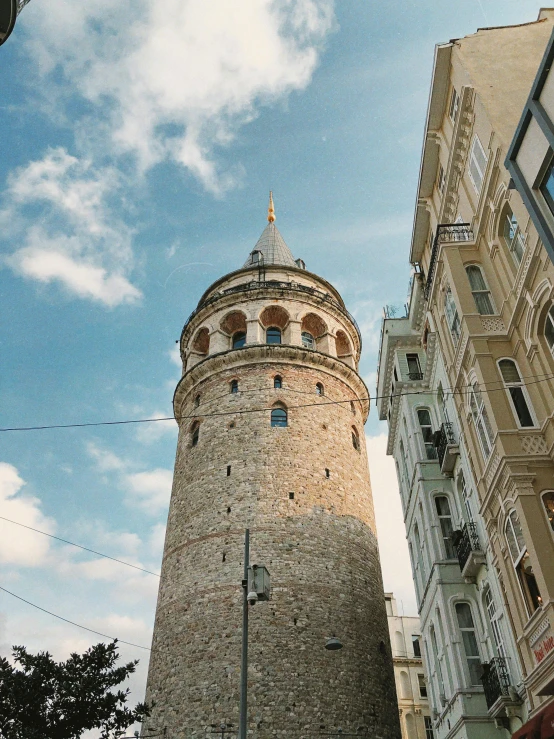 a stone tower with windows is next to buildings