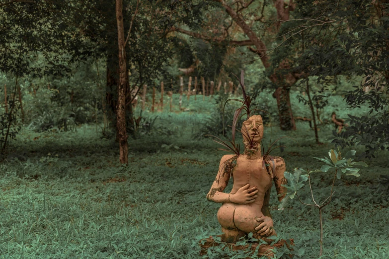 a statue sitting in the middle of a lush green forest