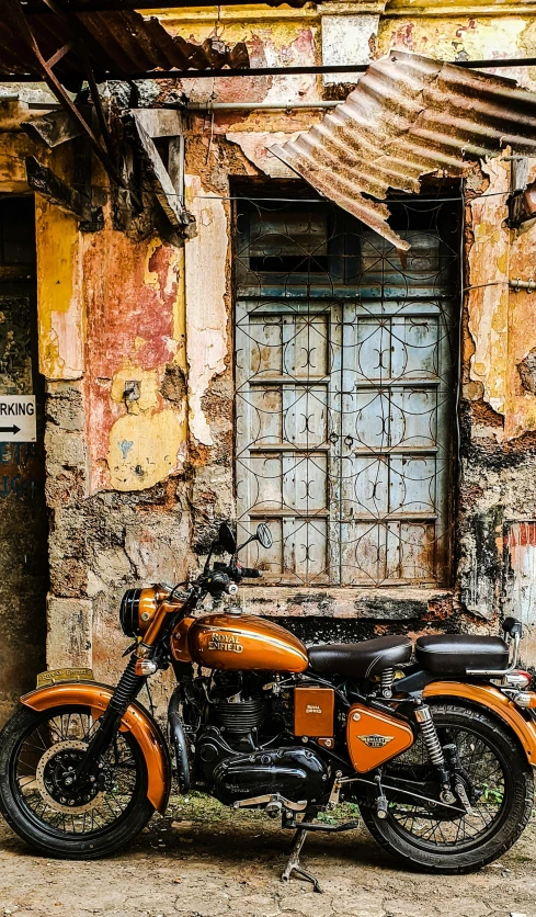 orange motorcycle in front of an old building