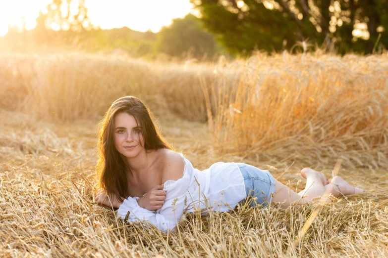 a woman laying on the grass in a field