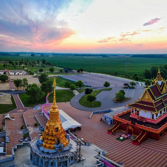 a large red and gold temple in the middle of a field