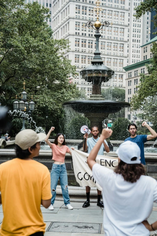 a crowd of people in a city with one holding a banner and the other is taking pictures