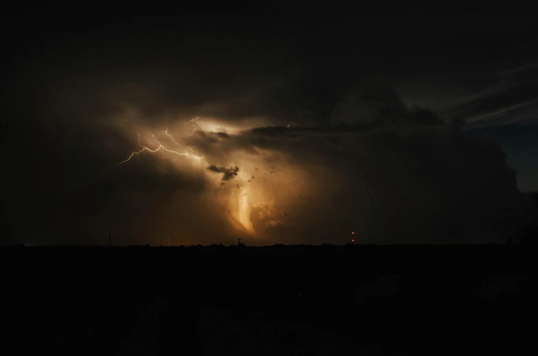 a large cloud filled with lightning on a night sky