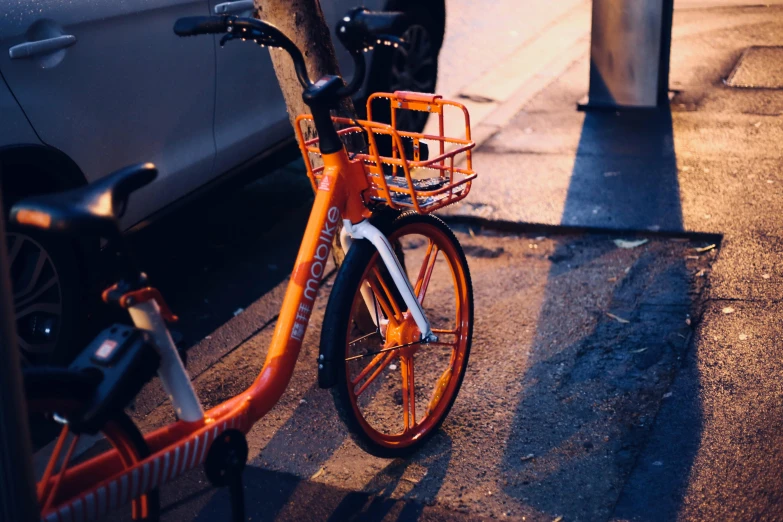 an orange bike parked on the side of a road