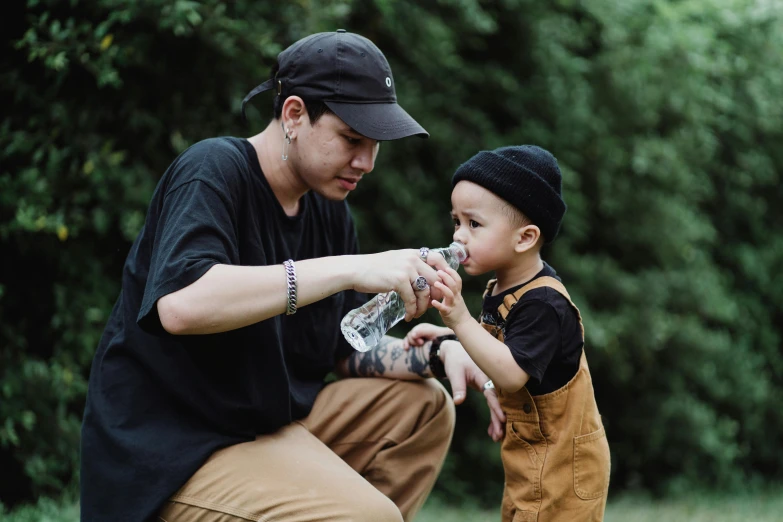 a man kneeling down to touch a 's hand