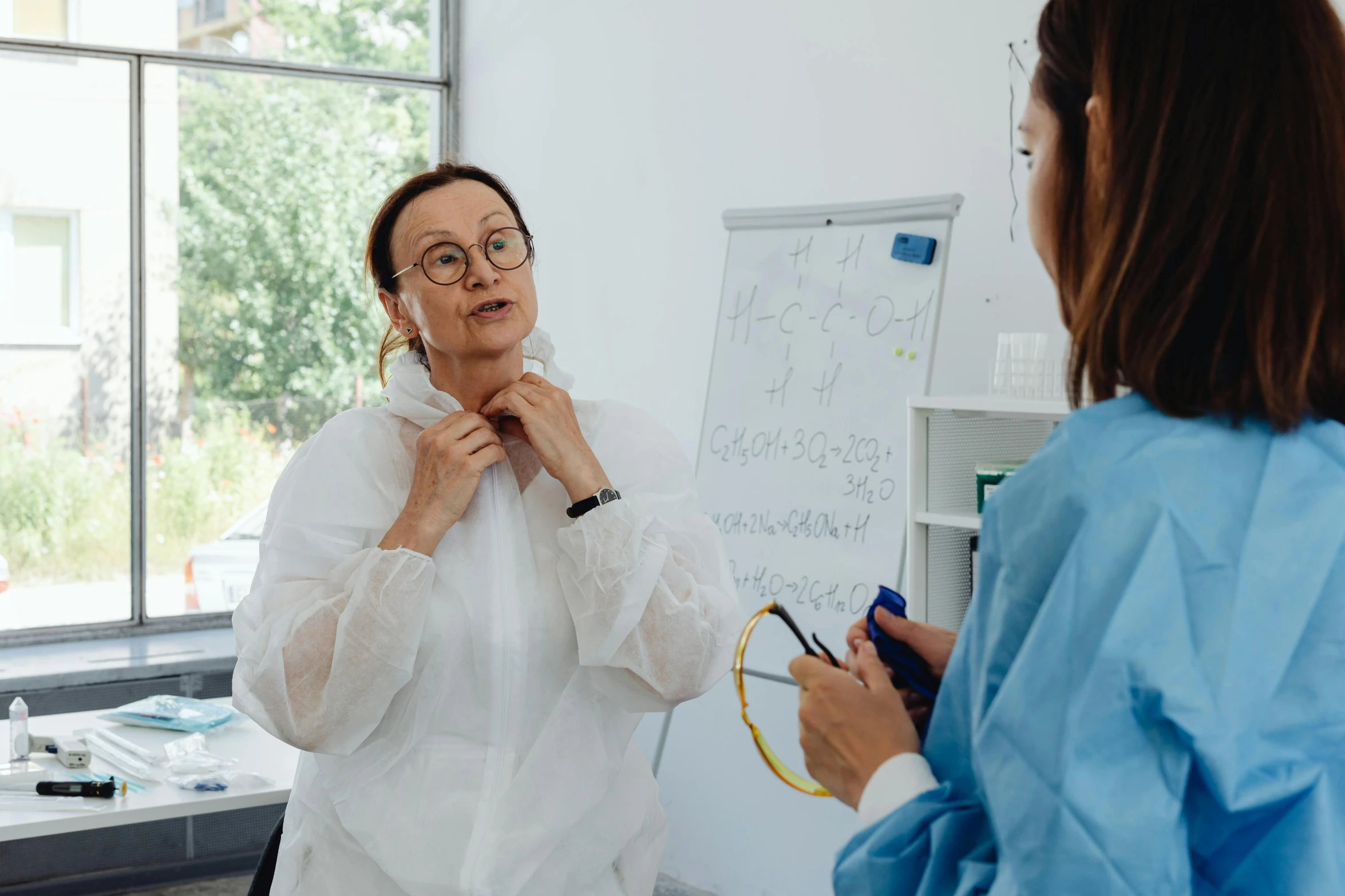 a woman wearing glasses looking at her doctor in the mirror