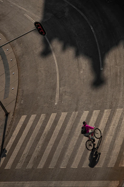 an overhead view of a person on a bicycle at an intersection