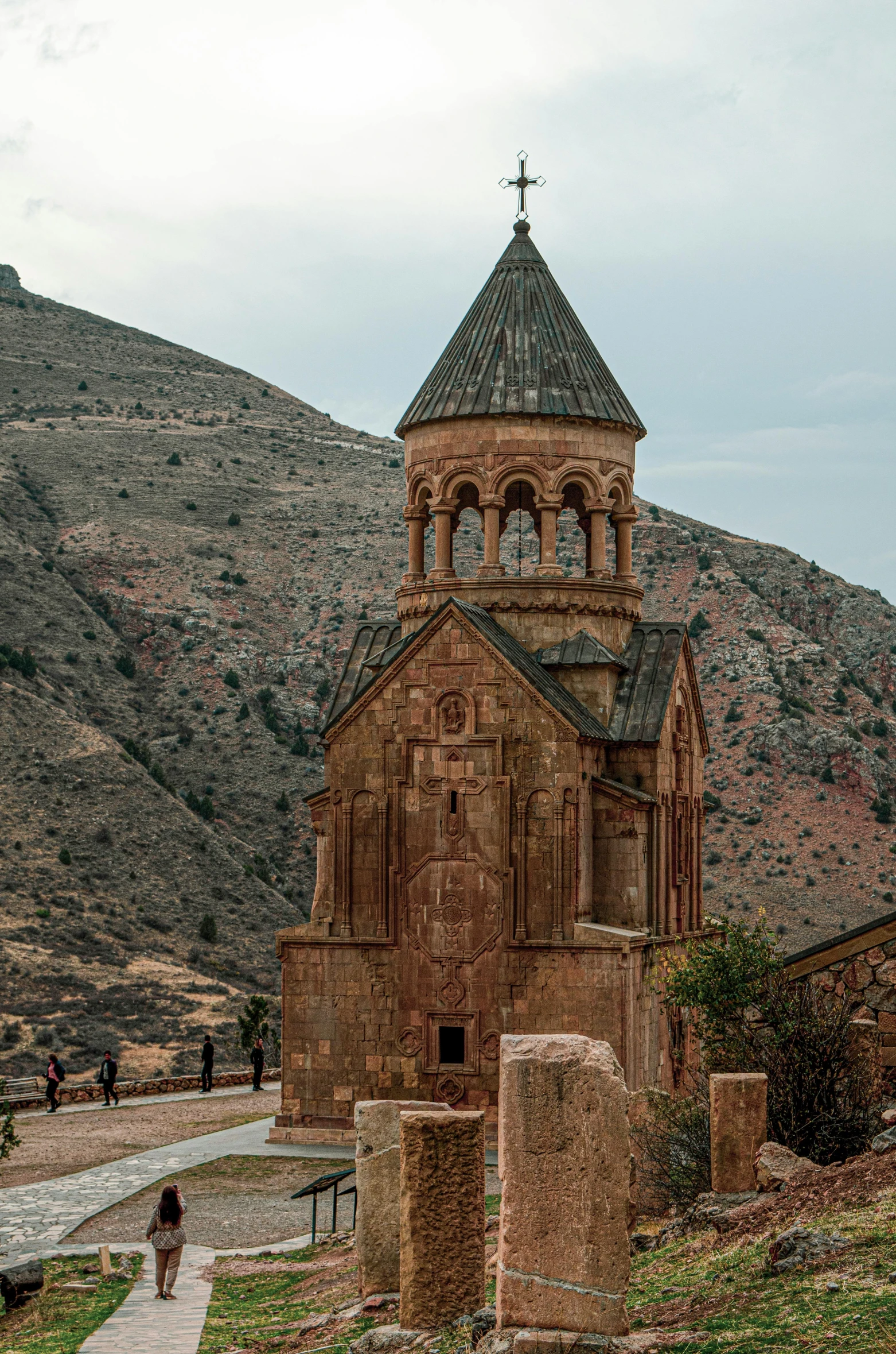 a tall church tower is surrounded by mountains