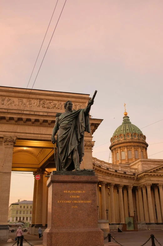 a statue stands in front of a domed building