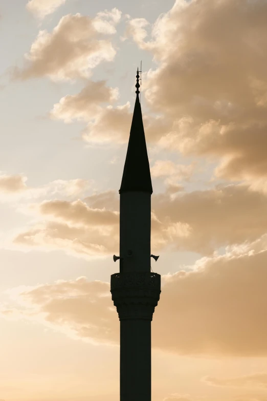 a tower with two clocks in front of a sunset sky