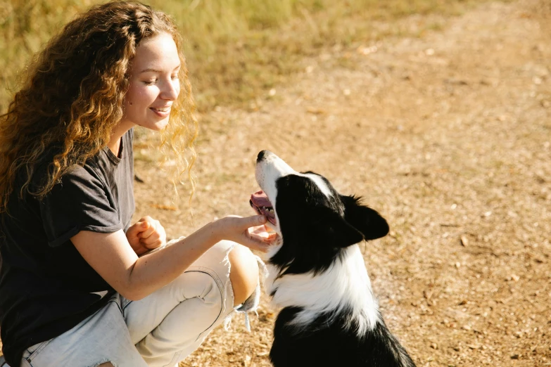 the girl is playing with her dog outdoors